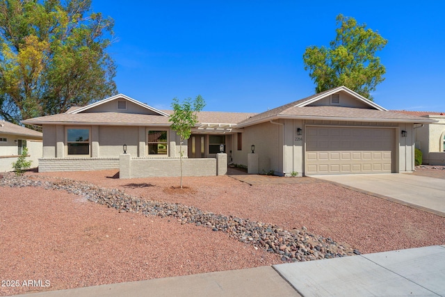 ranch-style house with a shingled roof, an attached garage, concrete driveway, and fence