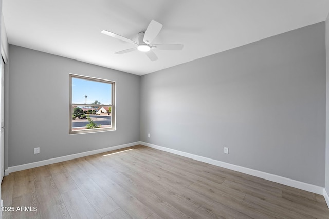 spare room with ceiling fan, baseboards, and wood finished floors