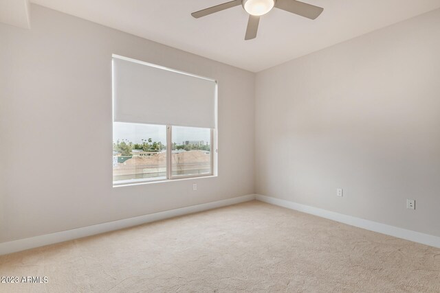 spare room featuring ceiling fan and light carpet