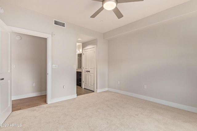unfurnished bedroom with carpet, baseboards, a ceiling fan, and ensuite bath