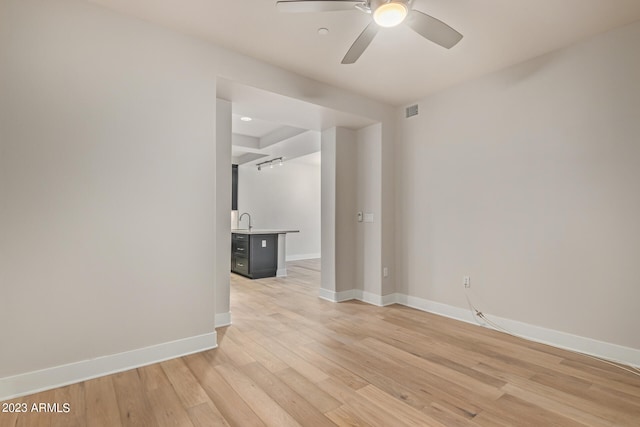 empty room featuring sink, ceiling fan, and light hardwood / wood-style flooring