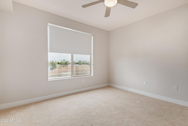 carpeted empty room with ceiling fan and baseboards