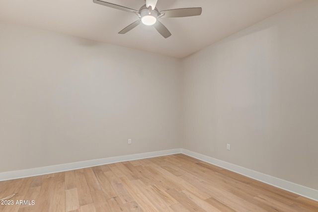 spare room with light wood finished floors, baseboards, and a ceiling fan