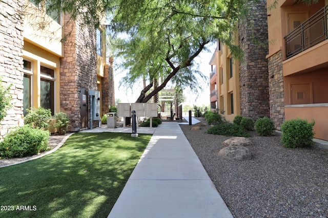 view of community with a mail area and a lawn