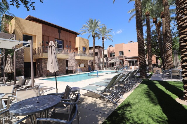 view of pool with a lawn and a patio area