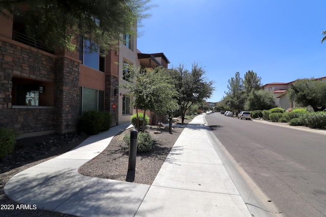 view of asphalt road with sidewalks and curbs