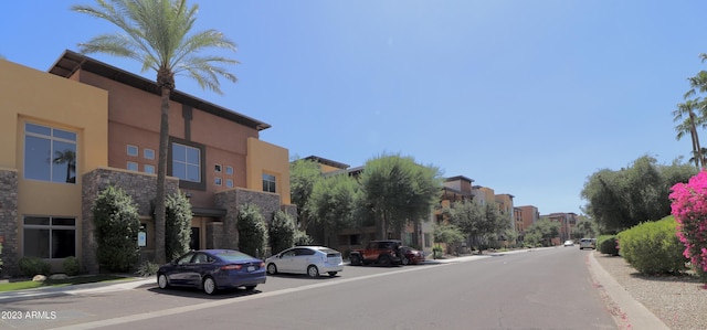 view of asphalt street featuring a residential view and curbs