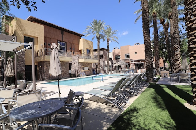 community pool with a patio and a residential view