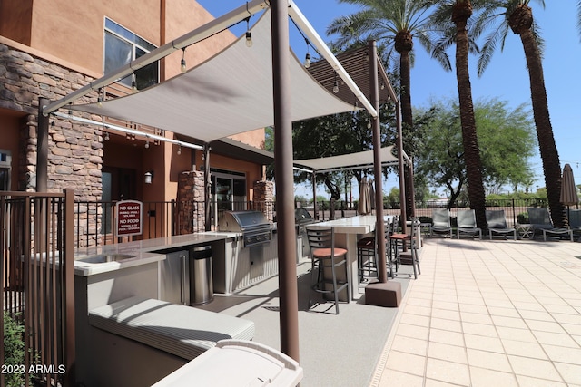 view of patio with area for grilling and fence