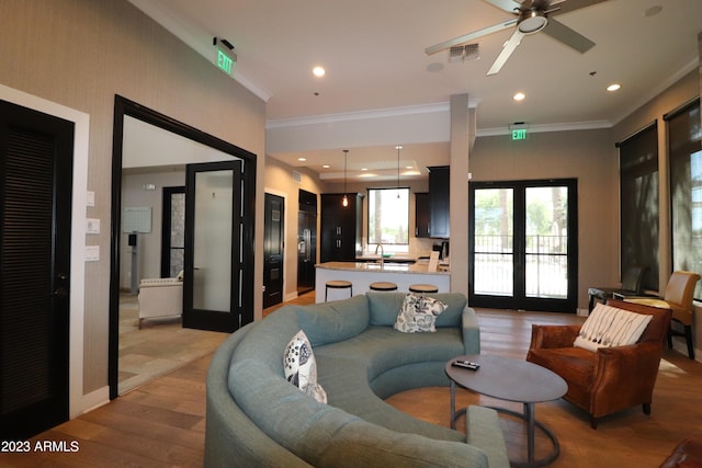 living room with sink, french doors, ornamental molding, and light hardwood / wood-style flooring