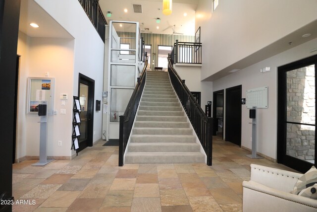 staircase featuring a towering ceiling