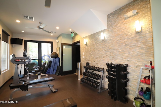 workout area featuring recessed lighting and brick wall