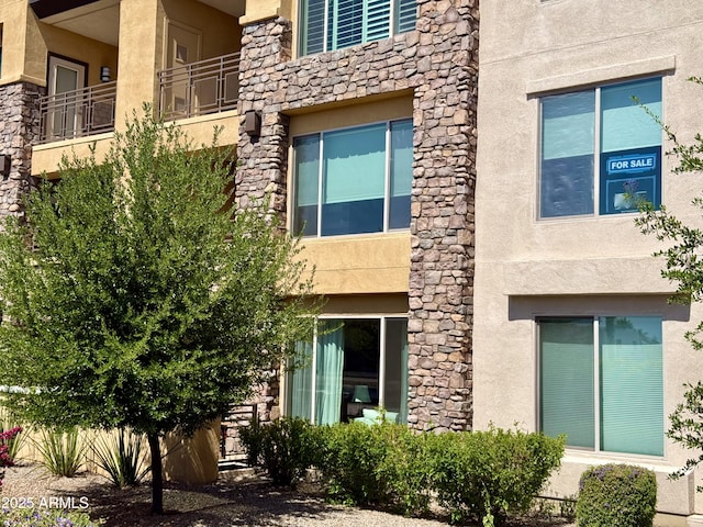 view of side of home featuring stone siding and stucco siding
