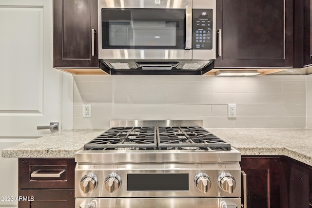 kitchen with dark brown cabinets, stainless steel appliances, and light stone countertops