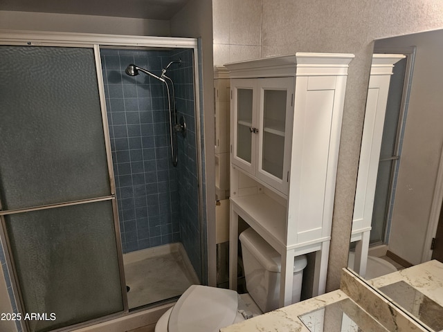 bathroom with a shower stall and toilet