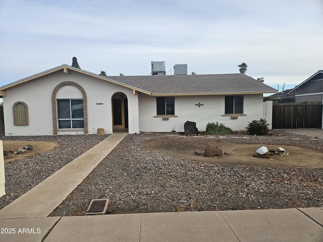 single story home with a shingled roof, fence, and stucco siding