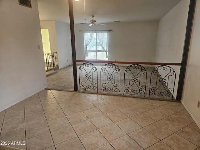 unfurnished room with visible vents, carpet, a ceiling fan, and tile patterned flooring