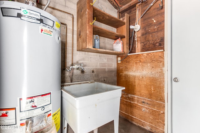 utility room featuring gas water heater and sink