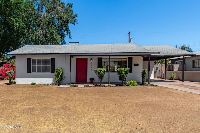 ranch-style home featuring a front lawn and a carport