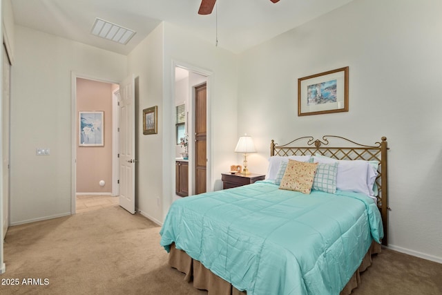 bedroom featuring ceiling fan, ensuite bath, and light carpet