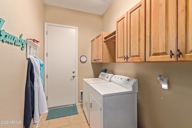 laundry room with light tile patterned floors, separate washer and dryer, and cabinets