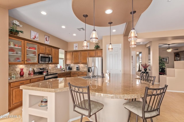 kitchen with stainless steel appliances, sink, tasteful backsplash, and decorative light fixtures