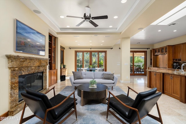 living room featuring a raised ceiling, plenty of natural light, and sink