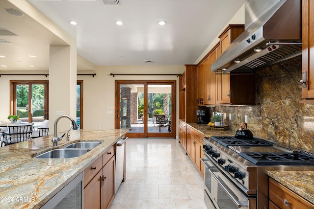 kitchen with sink, stainless steel appliances, plenty of natural light, and wall chimney range hood