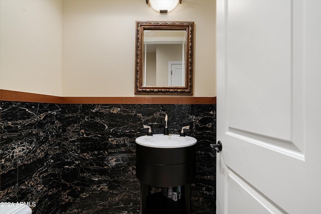 bathroom with vanity and tile walls