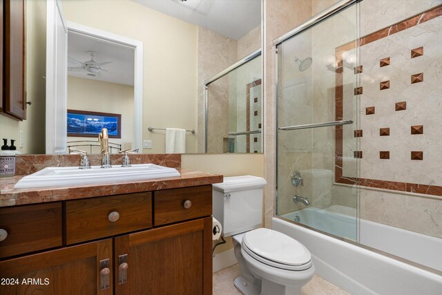 full bathroom with vanity, ceiling fan, toilet, and bath / shower combo with glass door