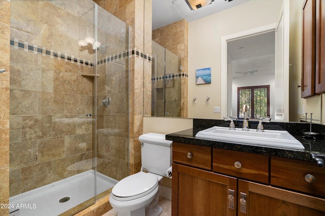 bathroom featuring vanity, ceiling fan, toilet, and a shower with shower door