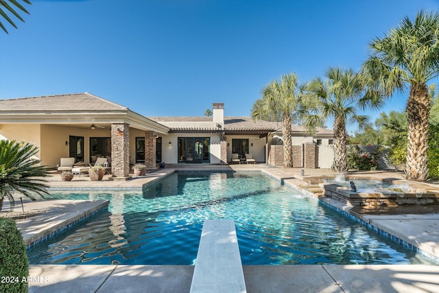 view of swimming pool with an in ground hot tub, a patio, ceiling fan, and a diving board