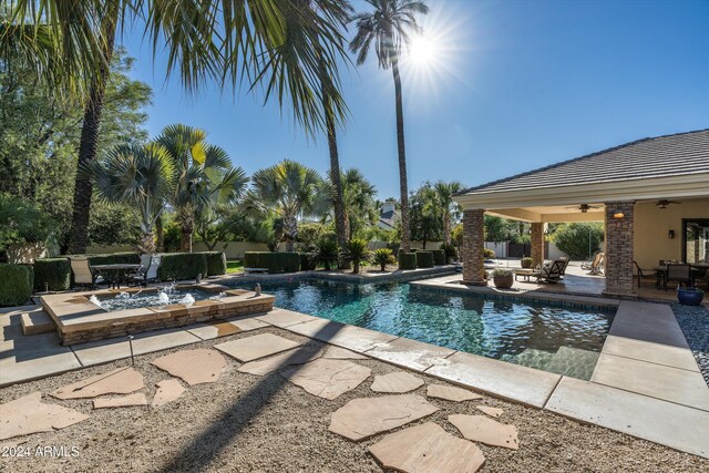 view of pool featuring ceiling fan, pool water feature, and a patio