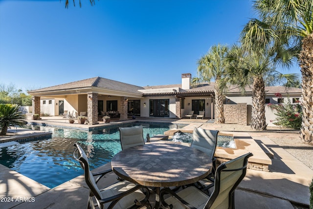 view of pool featuring pool water feature and a patio