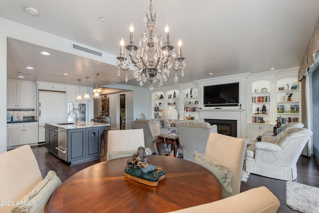 dining space featuring visible vents, dark wood finished floors, a chandelier, recessed lighting, and a fireplace