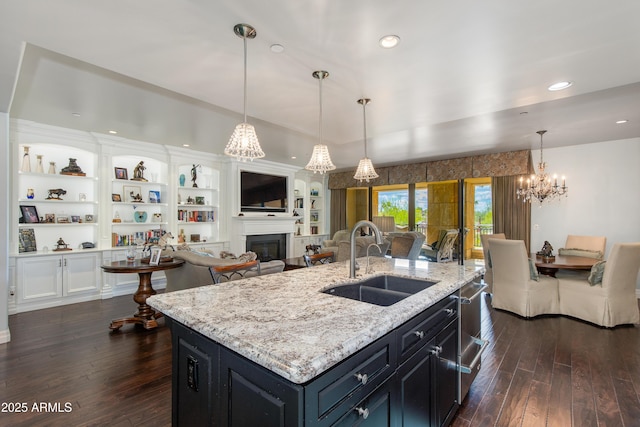 kitchen featuring open floor plan, a fireplace, dark wood-style flooring, and a sink