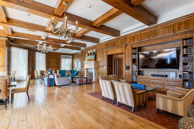 living room with coffered ceiling, plenty of natural light, a notable chandelier, and hardwood / wood-style flooring