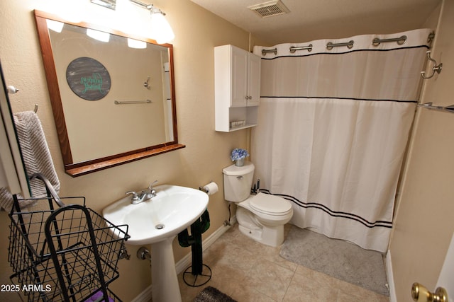 bathroom featuring tile patterned flooring, a shower with shower curtain, and toilet