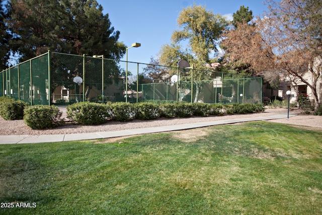 view of tennis court featuring a yard, community basketball court, and fence