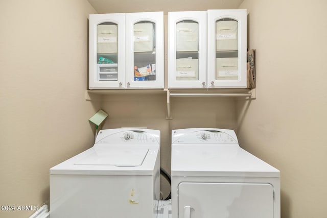 laundry room featuring cabinets and washer and clothes dryer