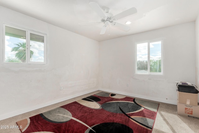 spare room featuring a ceiling fan and baseboards