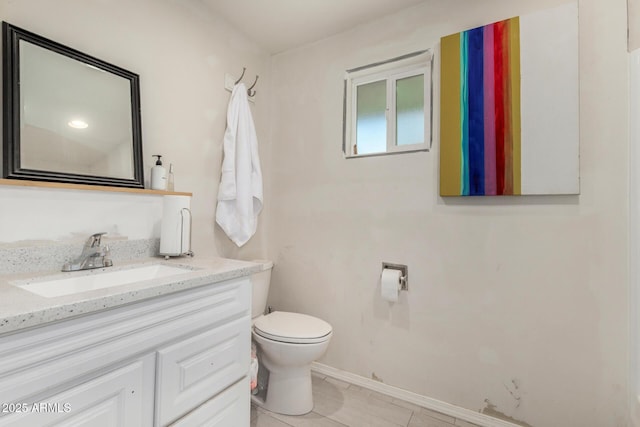 bathroom with toilet, baseboards, and vanity