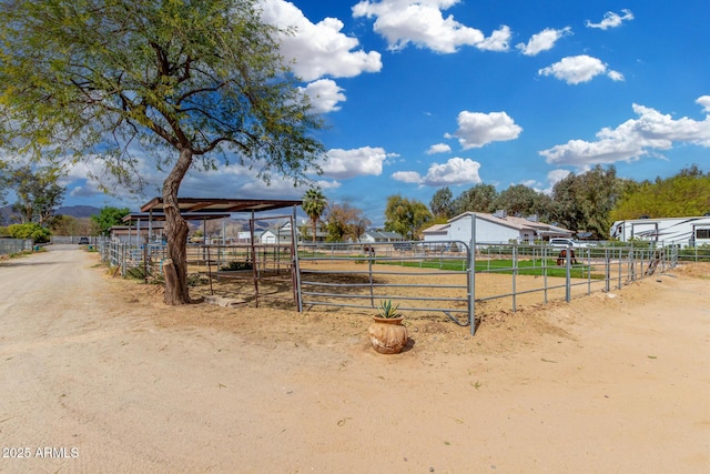 view of yard featuring a rural view, an exterior structure, and an outbuilding