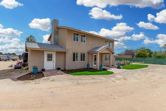 view of front of home featuring fence and stucco siding