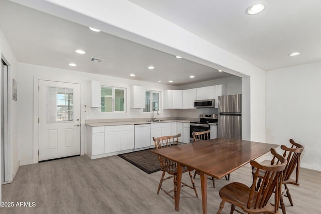 dining area featuring baseboards, light wood-type flooring, visible vents, and recessed lighting