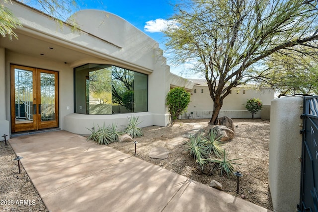 property entrance featuring a patio and french doors