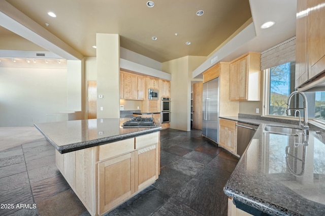 kitchen featuring built in appliances, sink, a kitchen island, and light brown cabinets