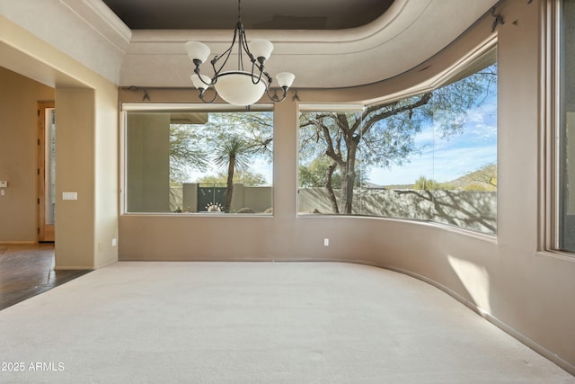 interior space with carpet floors, a wealth of natural light, and a chandelier