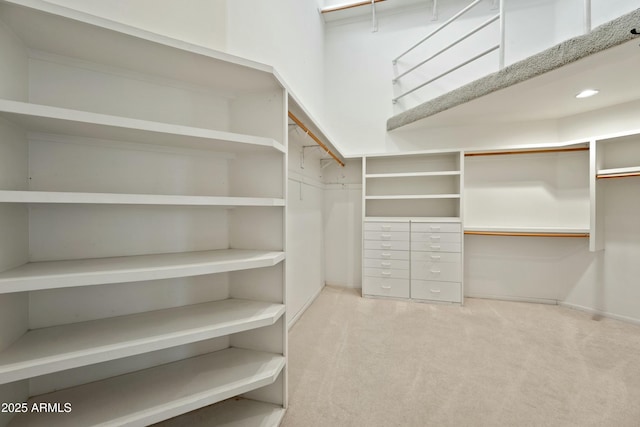 walk in closet featuring light carpet