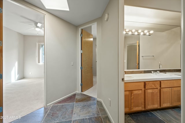 bathroom with vanity, a skylight, and ceiling fan